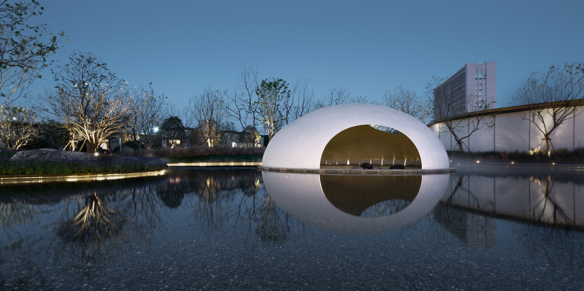 Pavillon in der Dämmerung, vom Wasser aus gesehen.