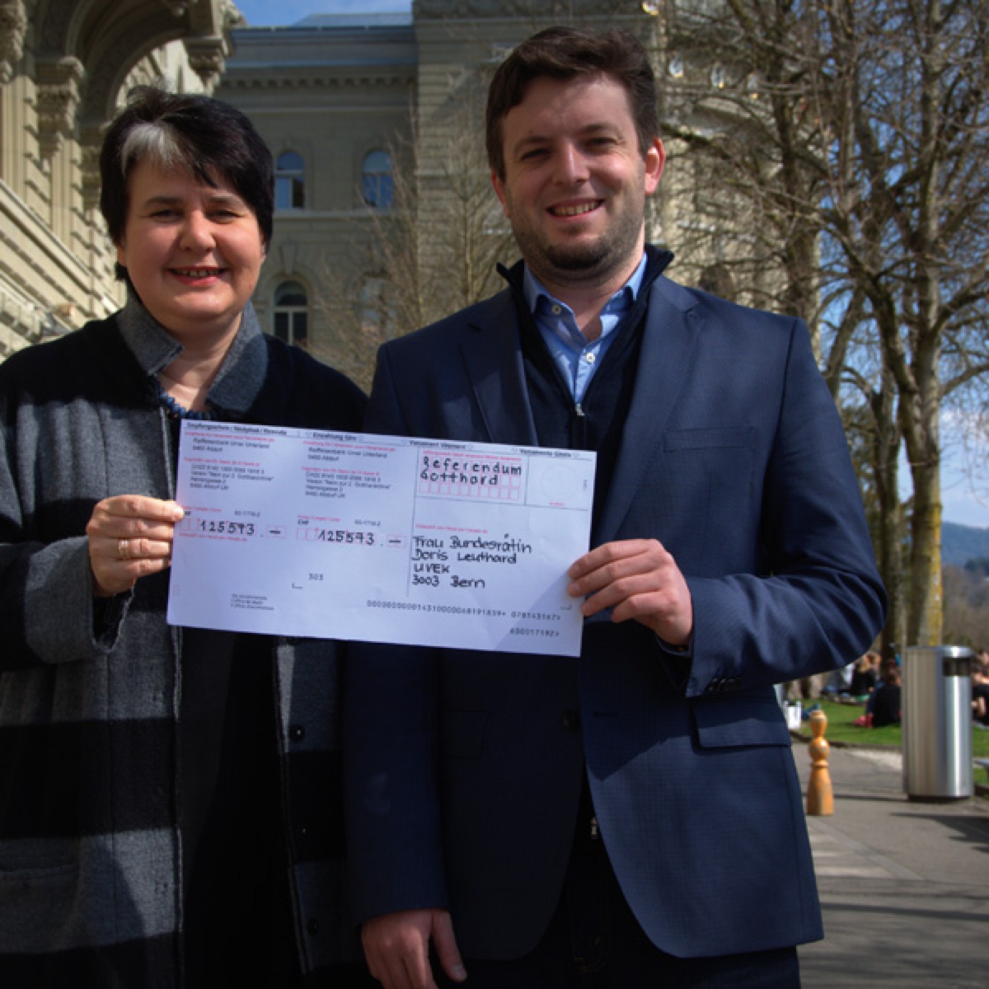 Die Co-Präsidenten Caroline Beglinger und Jon Pult mit dem Einzahlungsschein für Verkehrsministerin Doris Leuthard. (Bild zvg)