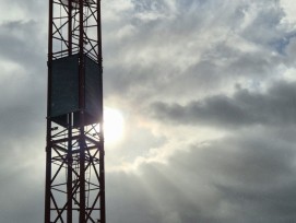 Kran vor bewölktem Himmel im Gegenlicht